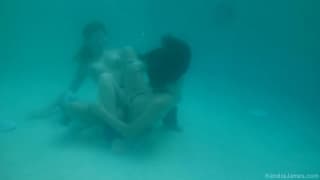 Deux lesbiennes le lèchent dans l'eau de la piscine